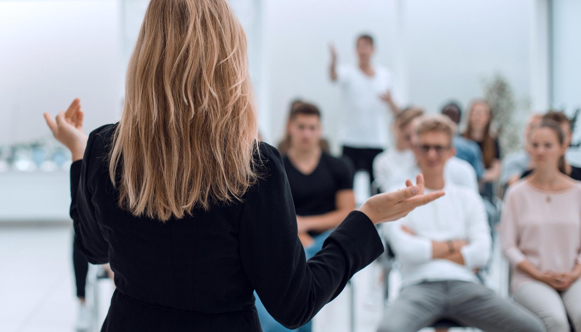 Trainerin vor Mitarbeitenden im Seminar | online Seminarverwaltung